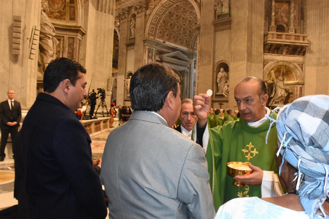 O governador Wellington Dias recebe a hóstia sagrada durante missa no Vaticano